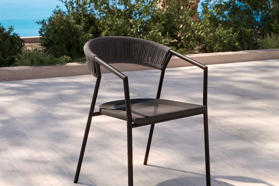 Sedia Maja MYYOUR con schienale intrecciato nero in giardino moderno