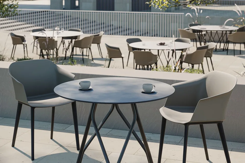 Tavolo da pranzo circolare Mimi con base architettonica intrecciata grigia per progetti contract e arredo spazi esterni professionali