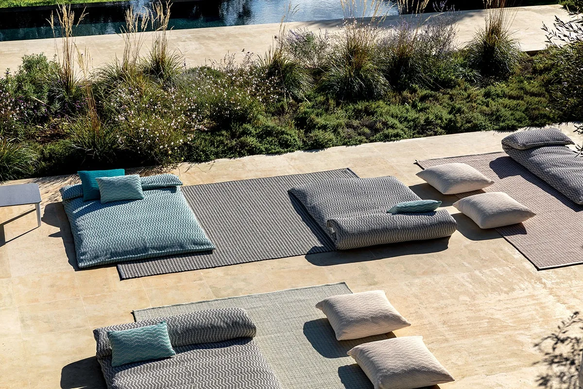 Cuscini decorativi per esterni della linea Wave MYYOUR su un tipico muretto a secco in Puglia