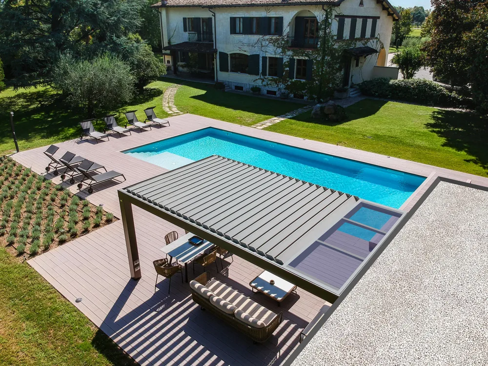 Pergola ARMONIA a bordo piscina vista dall’alto, con le lamelle e la porzione vetrata