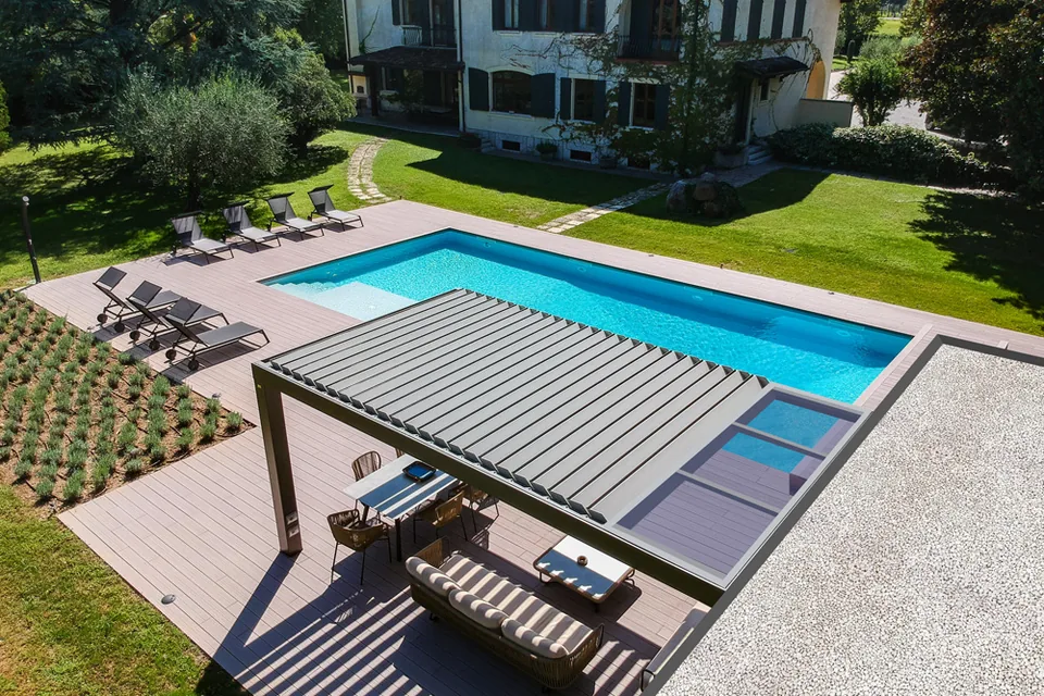 Pergola ARMONIA a bordo piscina vista dall’alto, con le lamelle e la porzione vetrata